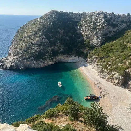 Grama Bay boat tour with turquoise waters and dramatic cliffs