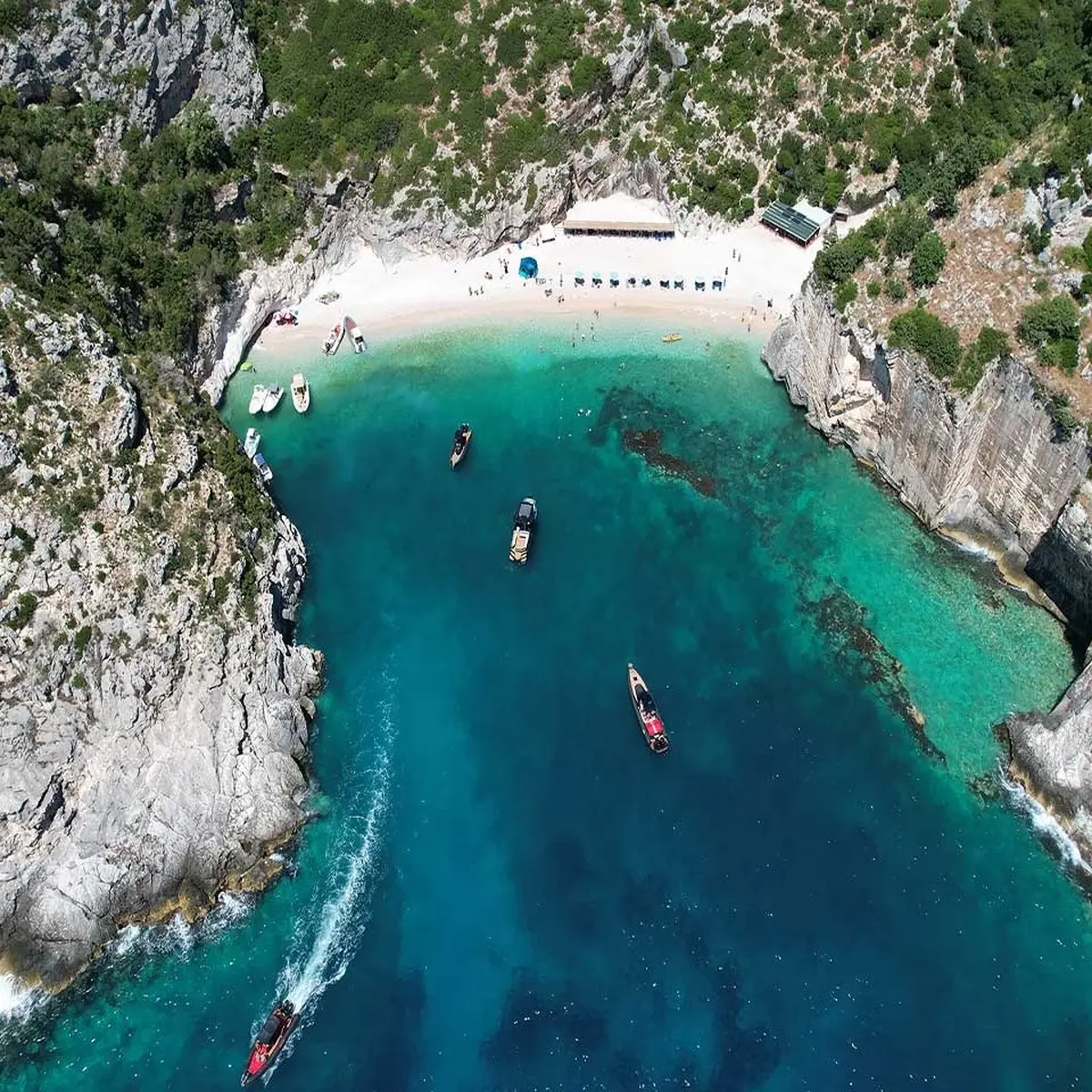 Grama Bay boat tour with turquoise waters and dramatic cliffs