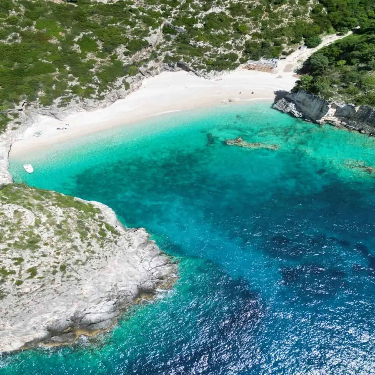 Grama Bay boat tour with turquoise waters and dramatic cliffs