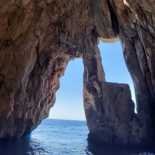 Pirates Cave boat tour with crystal-clear waters and rocky coastline