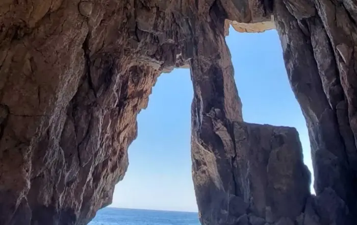 Pirates Cave boat tour with crystal-clear waters and rocky coastline