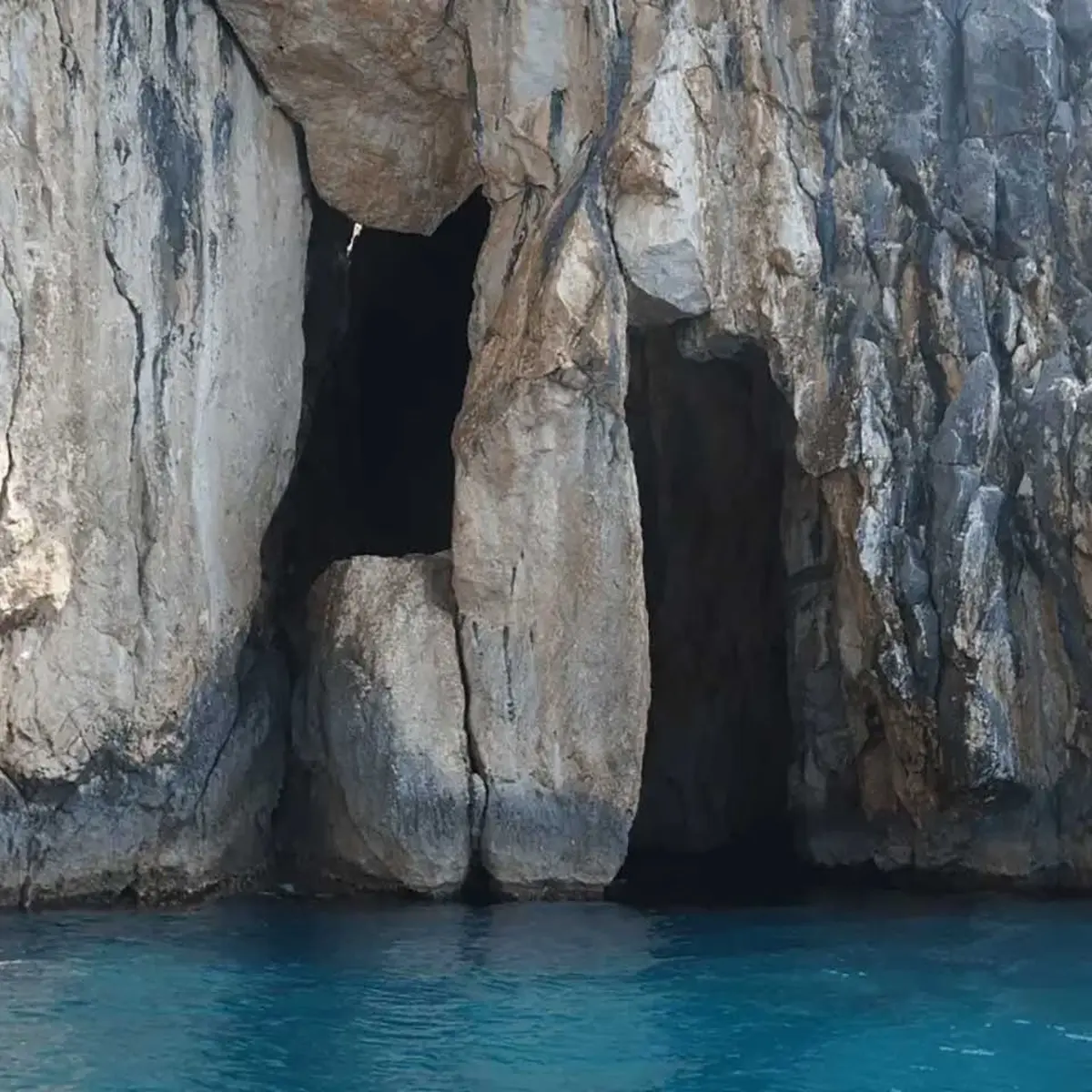 Pirates Cave boat tour with crystal-clear waters and rocky coastline