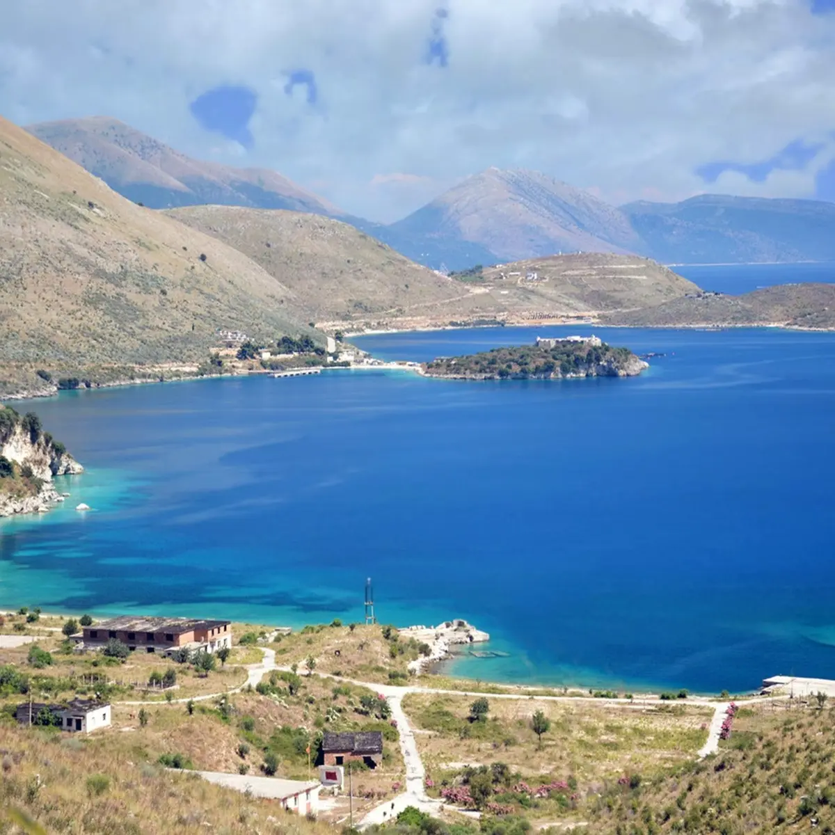 Porto Palermo boat tour with turquoise waters and historic castle views